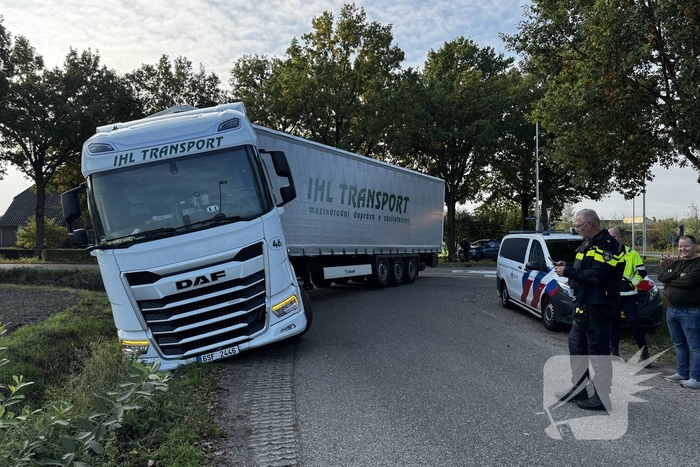 Vrachtwagencombinatie vast in berm