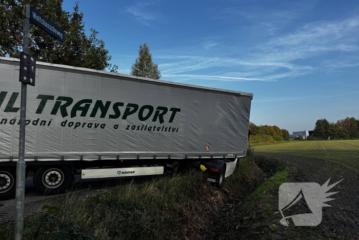 Vrachtwagencombinatie vast in berm