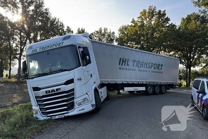 Vrachtwagencombinatie vast in berm