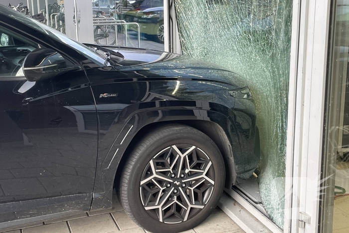 Automobilist ramt gevel supermarkt