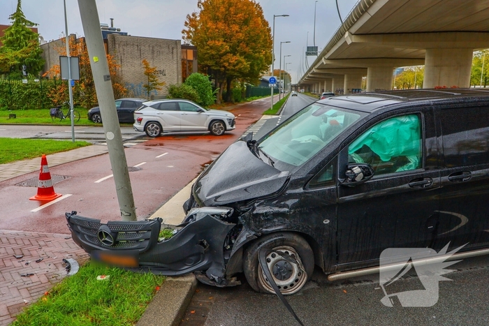 Bestelbus botst tegen lantaarnpaal