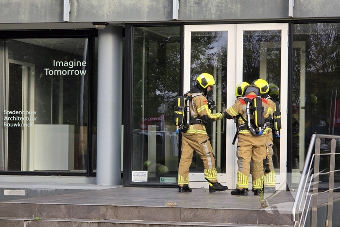 Kantoorpand brandt, rook uit bovenverdieping