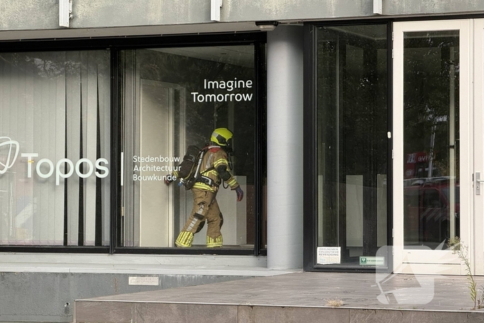 Kantoorpand brandt, rook uit bovenverdieping