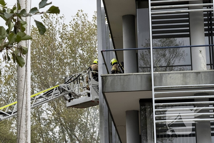Kantoorpand brandt, rook uit bovenverdieping