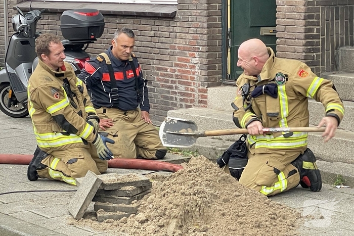 Brandweer graaft stoep open wegens leidingbreuk