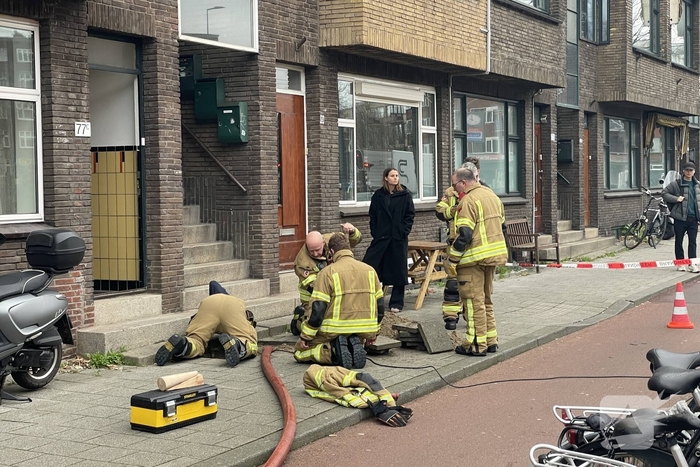 Brandweer graaft stoep open wegens leidingbreuk