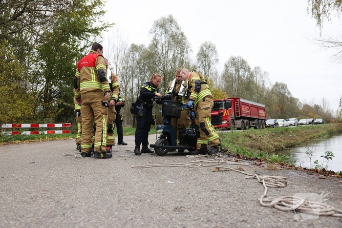 Man met scootmobiel te water