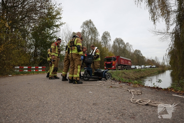 Man met scootmobiel te water