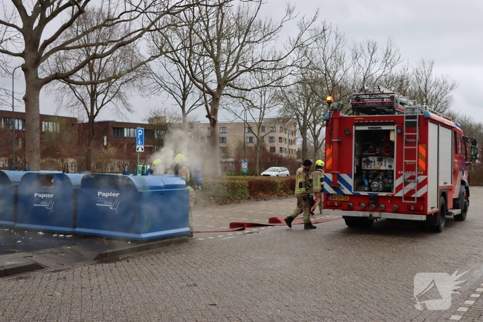 Brandweer dooft brand in papiercontainer