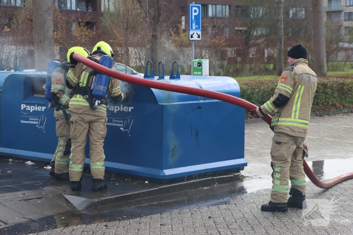 Brandweer dooft brand in papiercontainer