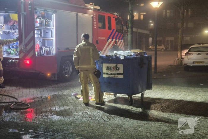 Brandweer dooft brand in papiercontainer