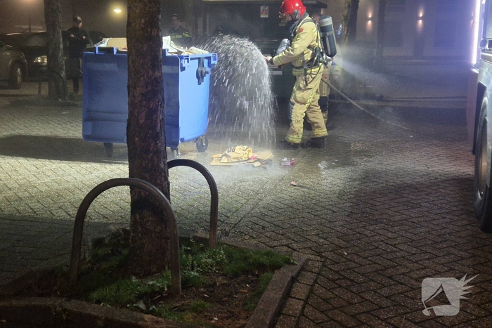 Brandweer dooft brand in papiercontainer