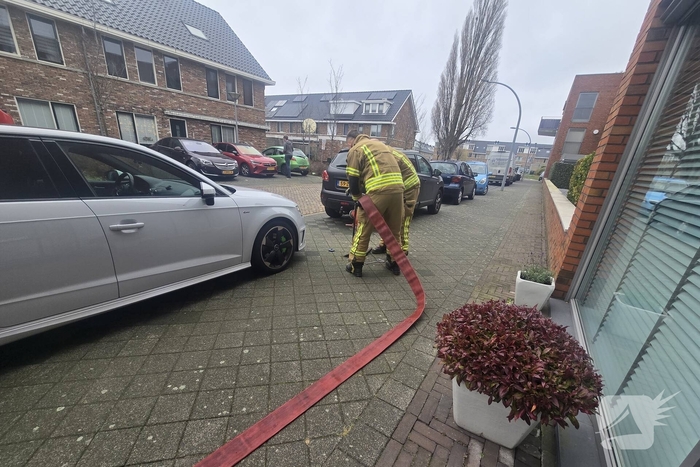 Container vat vlam door vuurwerk, omstanders doen bluspoging