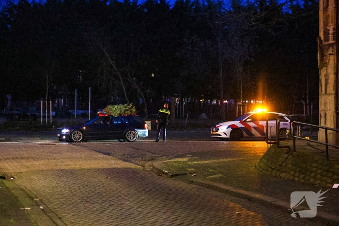 Auto met kerstboom op dak staande gehouden
