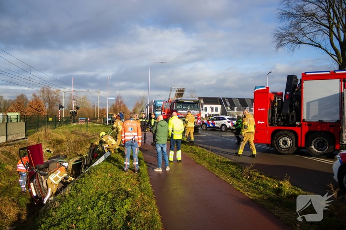 Auto op zijkant in greppel na ongeval