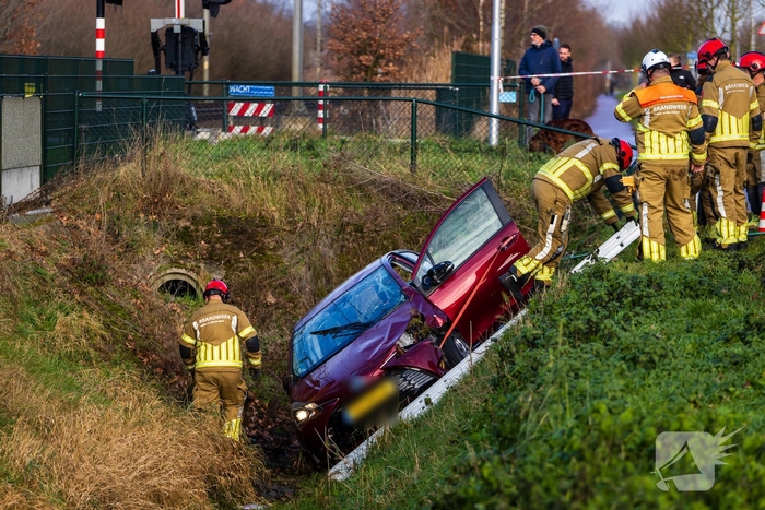 Auto op zijkant in greppel na ongeval