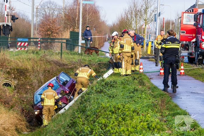 Auto op zijkant in greppel na ongeval
