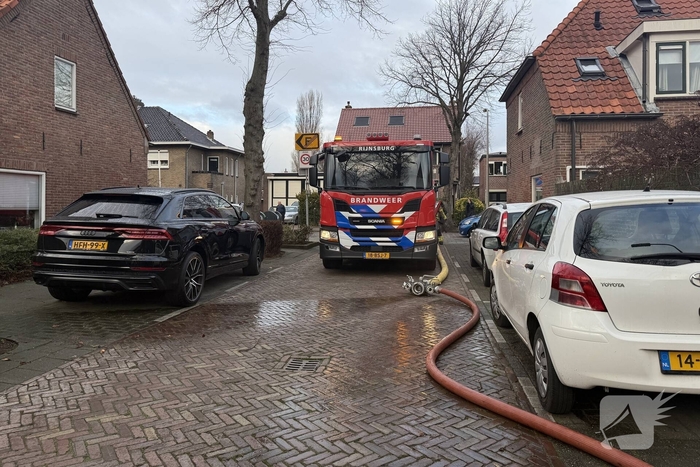 Vlammen, explosies en zwarte rook bij brand achter woning