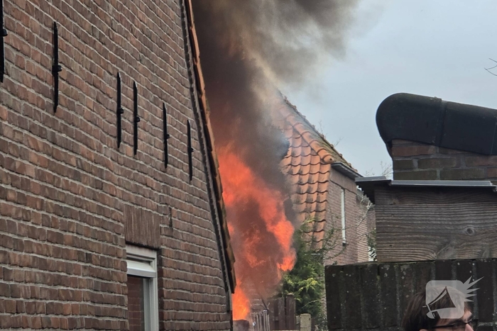 Vlammen, explosies en zwarte rook bij brand achter woning