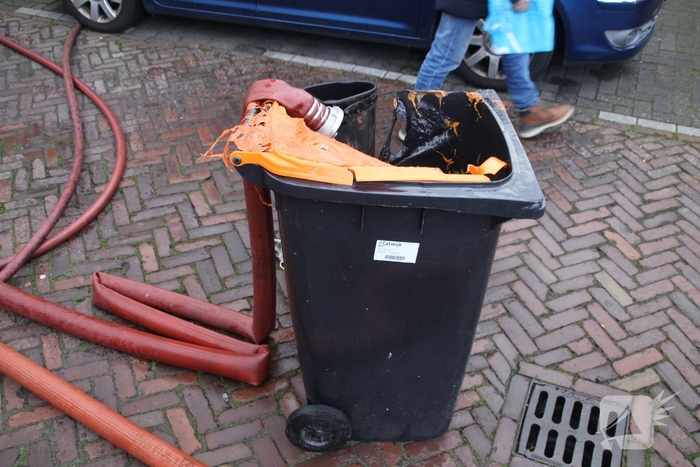 Vlammen, explosies en zwarte rook bij brand achter woning