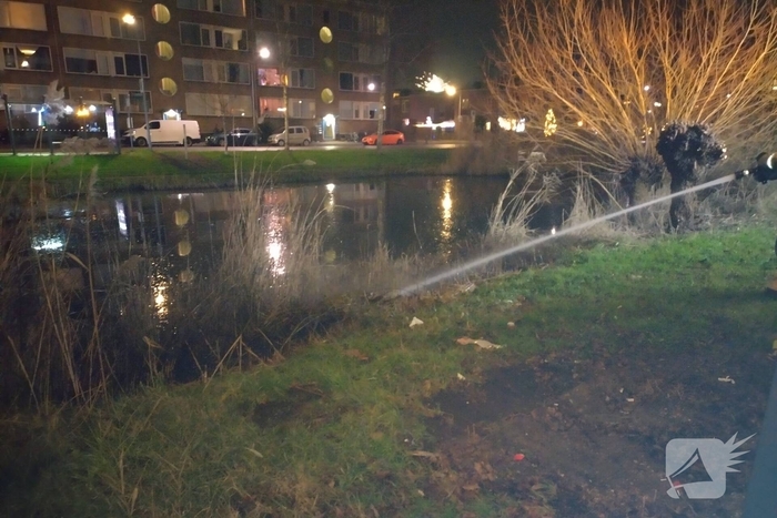 Brandweer blust brand langs sloot