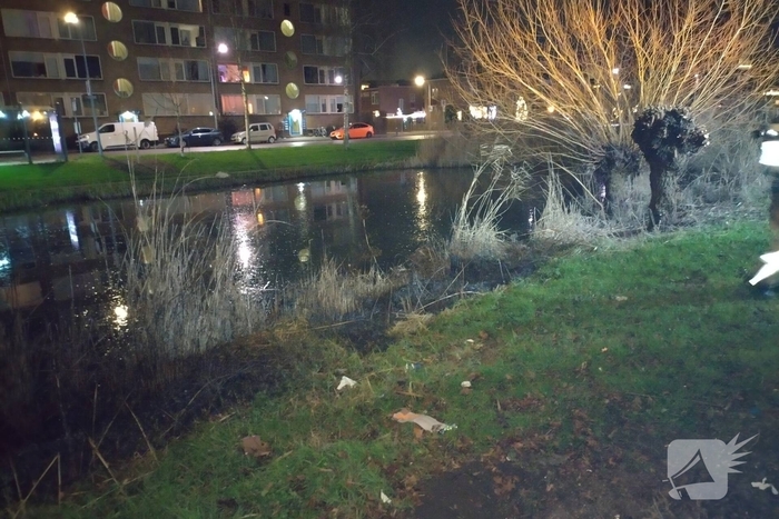 Brandweer blust brand langs sloot