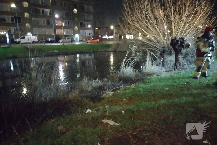 Brandweer blust brand langs sloot