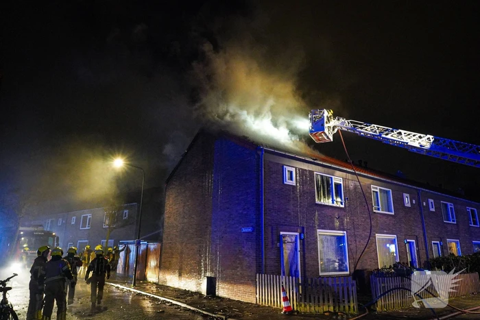 Rookwolken stijgen uit dak van woning