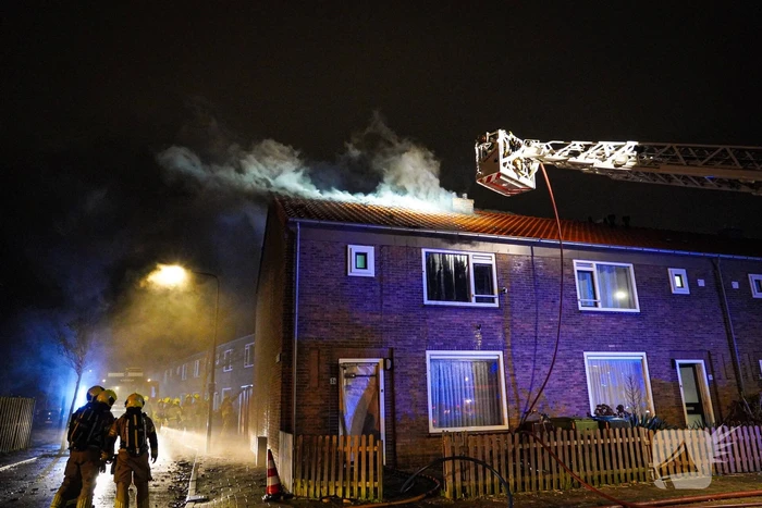 Rookwolken stijgen uit dak van woning