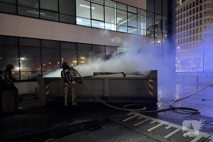 Bouwcontainer in brand vlakbij gebouw