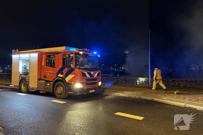 Bouwcontainer in brand vlakbij gebouw