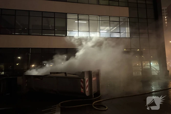 Bouwcontainer in brand vlakbij gebouw