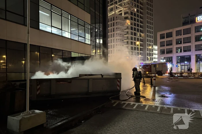 Bouwcontainer in brand vlakbij gebouw
