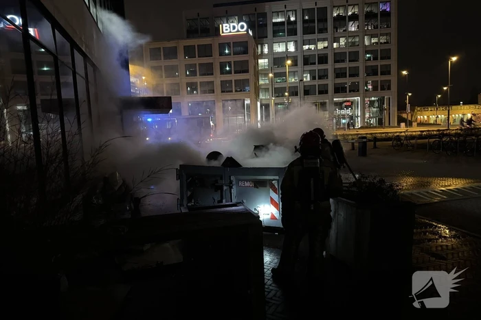 Bouwcontainer in brand vlakbij gebouw