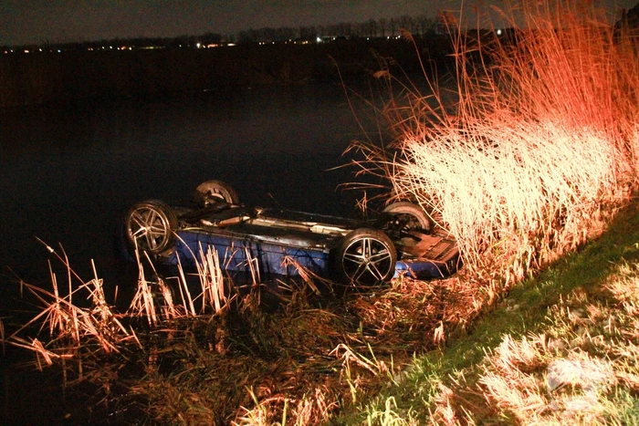 Auto belandt op de kop in het water