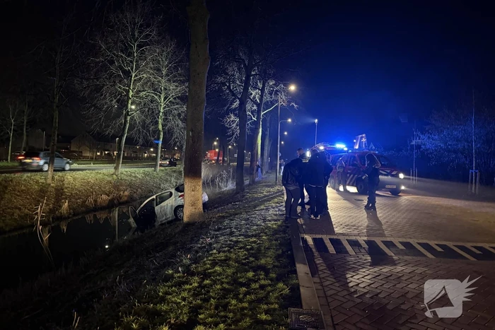 Personenauto belandt deels in water