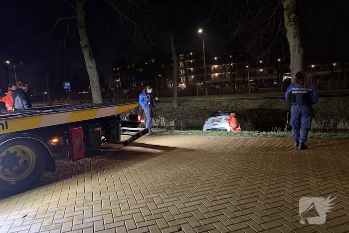 Personenauto belandt deels in water
