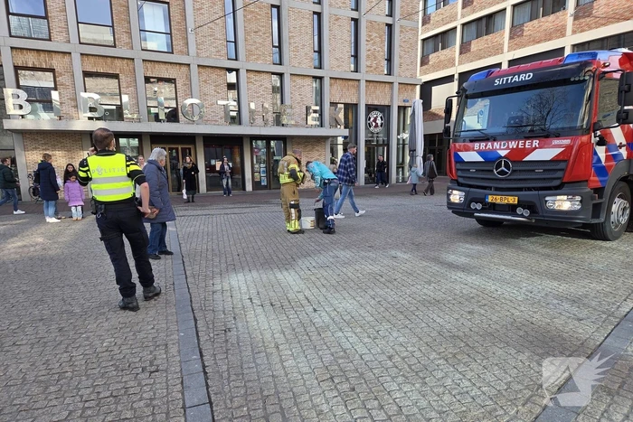 Verward persoon spuit met verf in bibliotheek