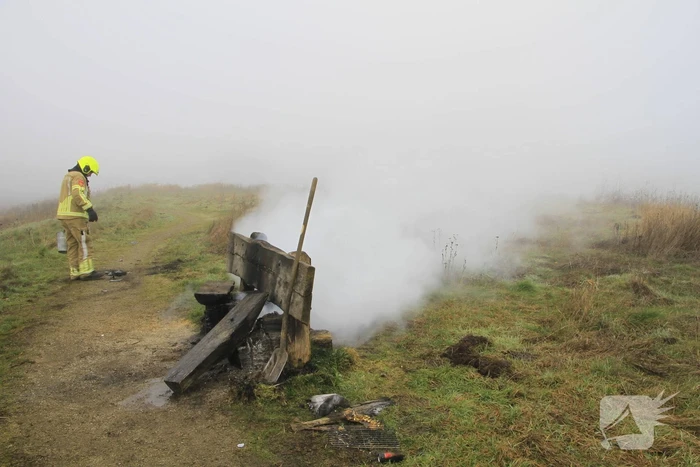Buitenbrand onder monumentale bank na barbecue