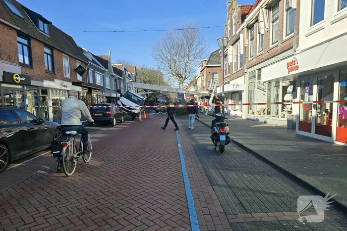 Hoogwerker kantelt tegen winkelpand
