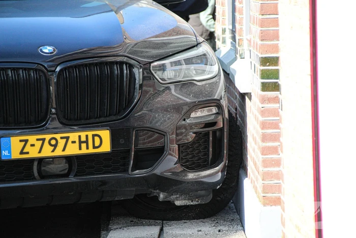 Auto botst tegen woning na aanrijding met paal