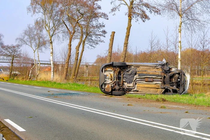 Auto belandt op zijn kant na botsing met boom