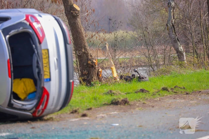 Auto belandt op zijn kant na botsing met boom