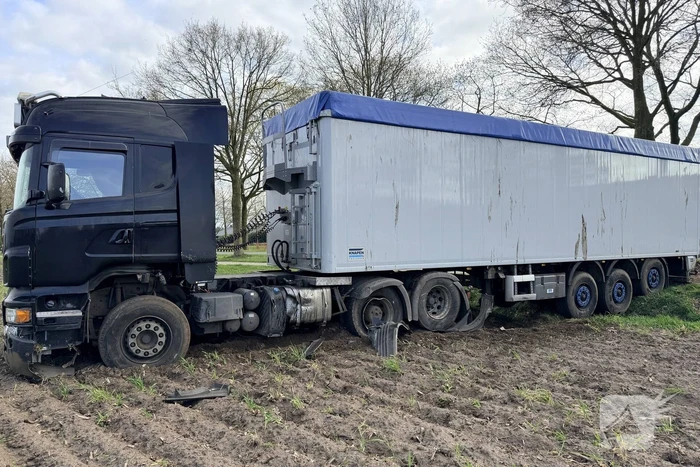 Vrachtwagen ramt auto en belandt in weiland