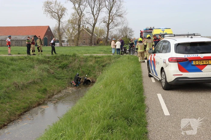 Persoon te water met scootmobiel