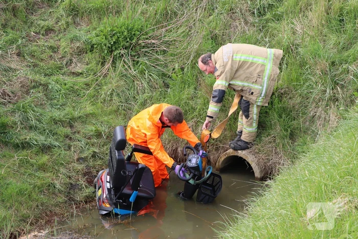Persoon te water met scootmobiel