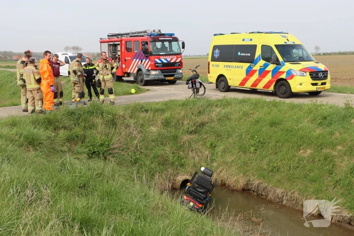 Persoon te water met scootmobiel