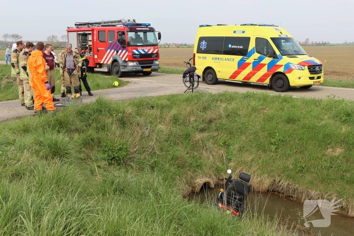 Persoon te water met scootmobiel