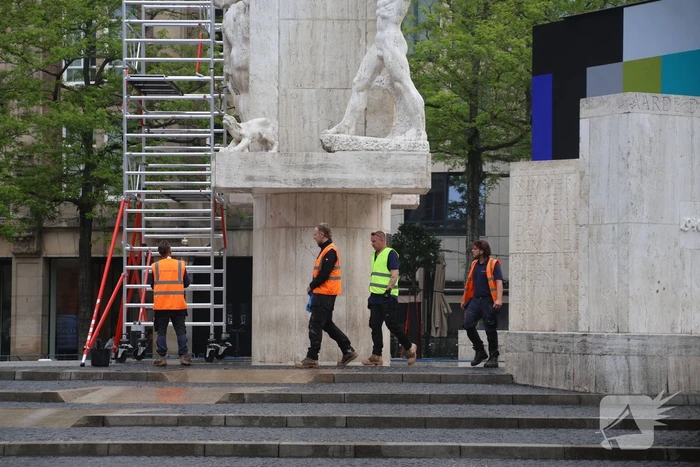 Schoonmaken van nationaal monument op Dam na bekladding