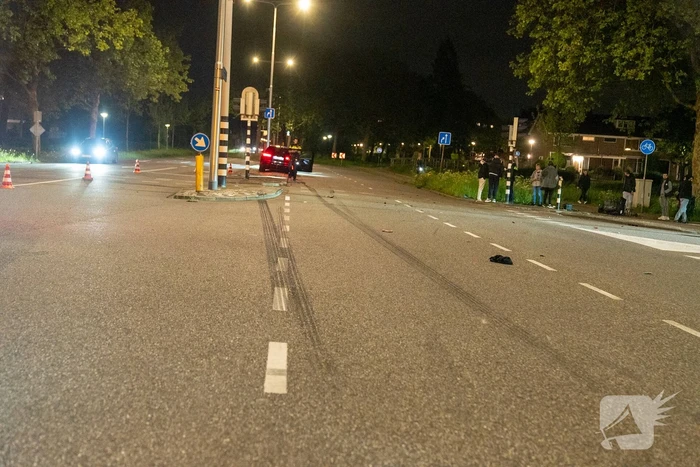 Auto schept een scooter